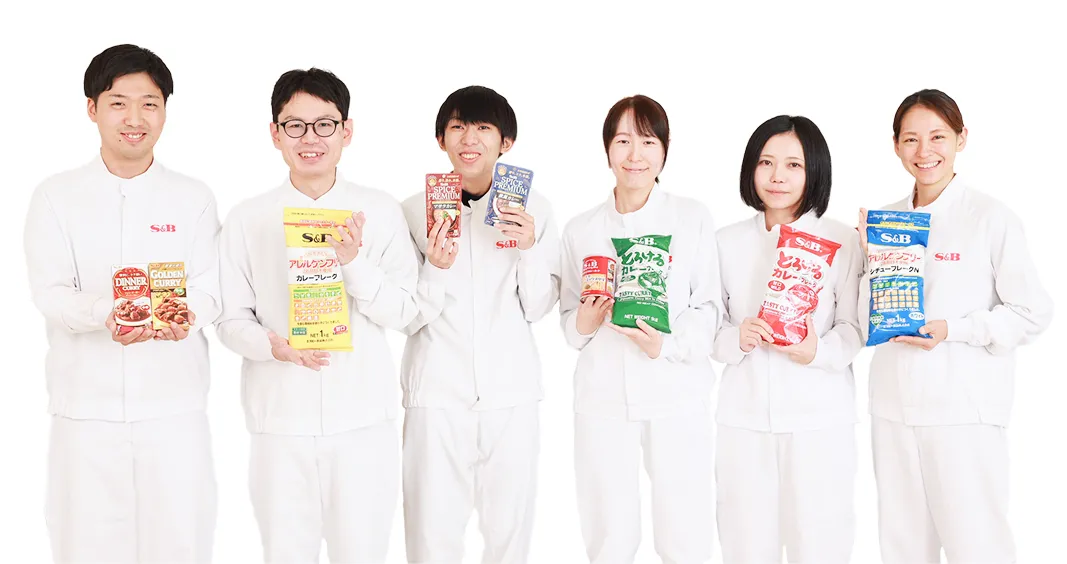白い作業着姿で製品を持つエスビー食品の従業員たち
